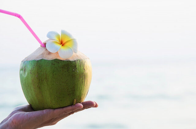 Woman Holding a Coconut With Straw in her hand | Benefits of Coconut Water