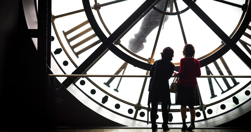 Women Standing Near Townhouse Clock | Does Time Pass Faster As You Get Older
