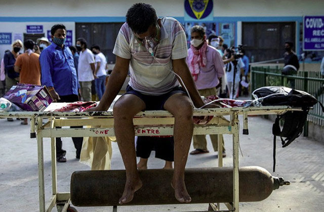 Man Sitting on a stretcher getting oxygen from oxygen cylinder | Dharamveer Solanki Hospital Covid O2 Crisis