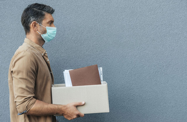 A man holding his office documents and other stuff in a carton | Job losses in Switzerland due to COVID