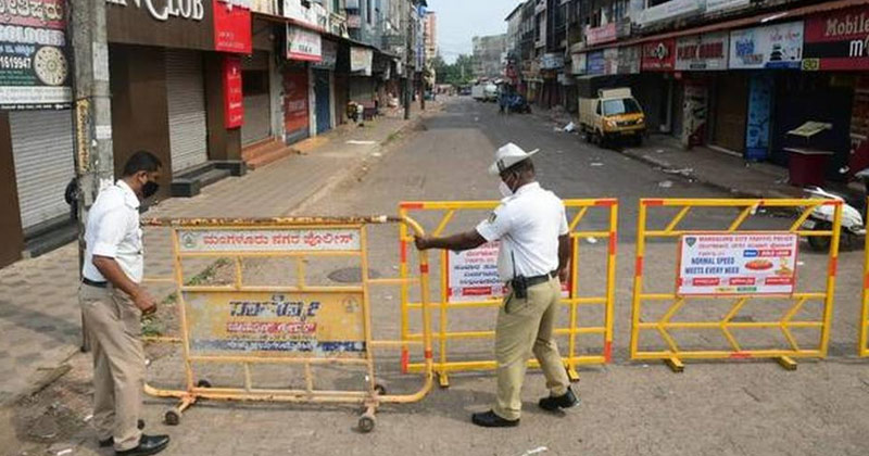 Traffic police personnels placing barriers on road | Karnataka Lockdown