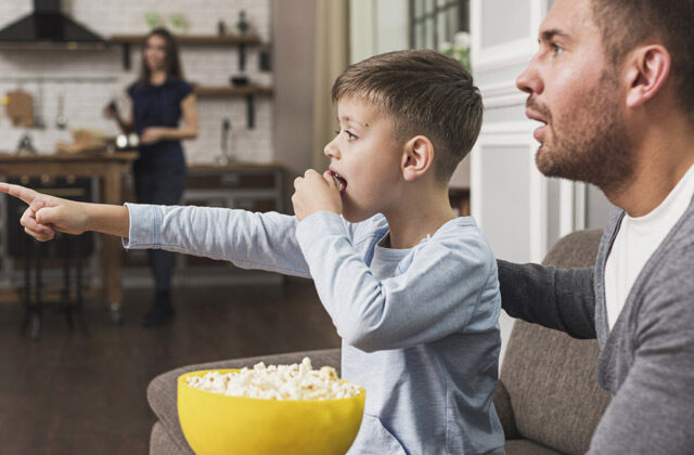 Father and Son watching movie while eating popcorn | Best Father's Day Movies