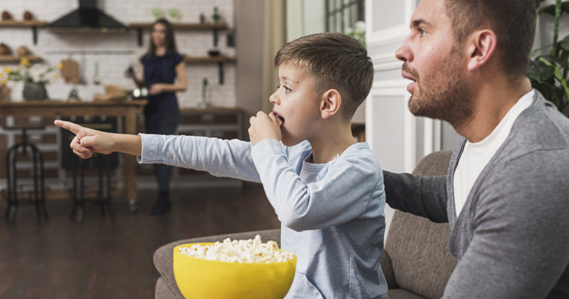 Father and Son watching movie while eating popcorn | Best Father's Day Movies