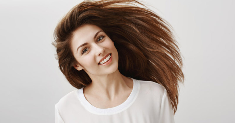 Smiling woman with long hair | Good Castor Oils for Hair
