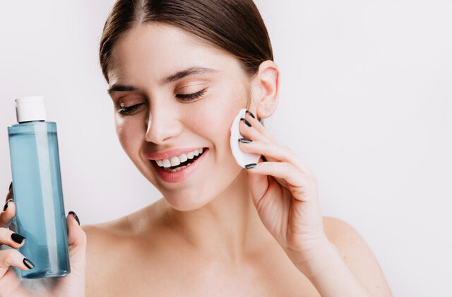 A woman applying homemade toner on her face with a cotton pad | How to Make Toner At Home