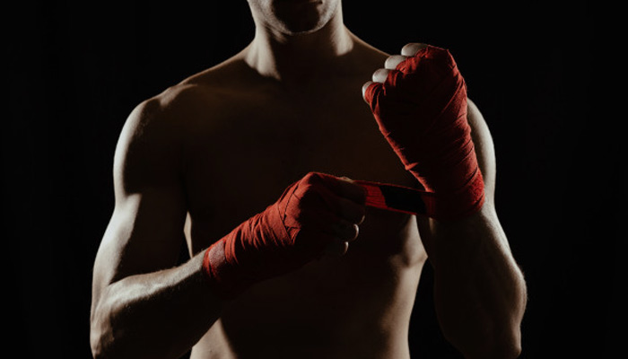 A Boxer Tightening his hand straps |