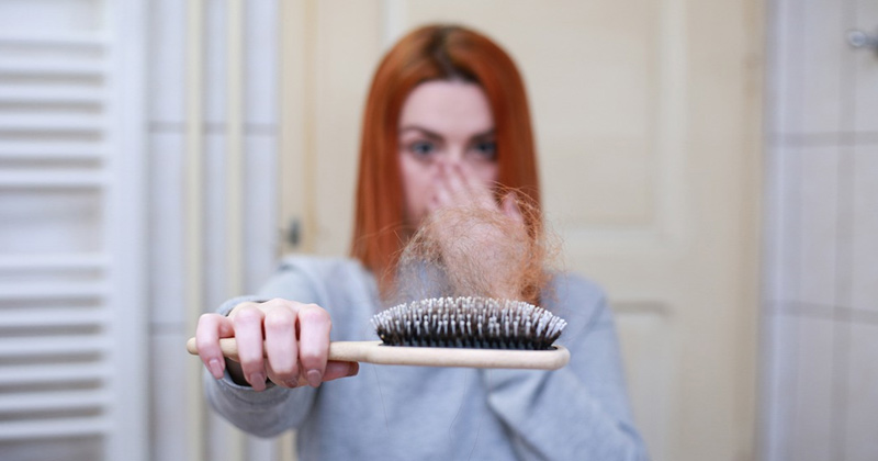 A Woman Showing her broken hair strands on a comb | Hair Loss Prevention Tips