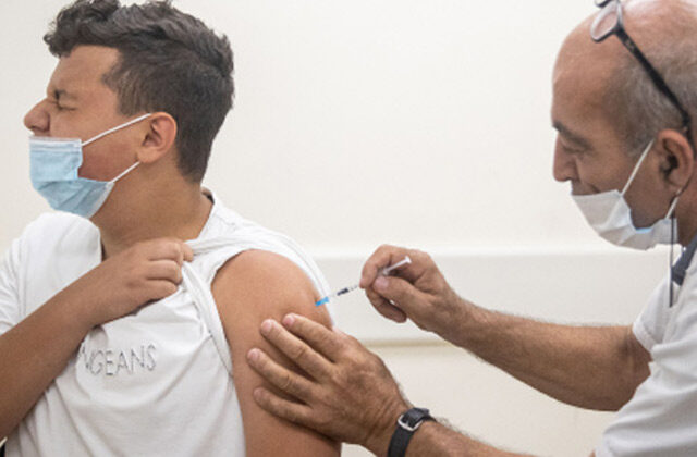 Health Worker Administering Vaccine to a person | Israel Rise in Delta Variant Cases